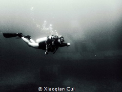 Nice diver with a wreck as background by Xiaoqian Cui 